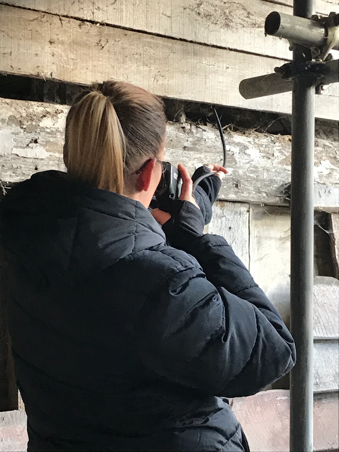 Woman with camera looking in wall
